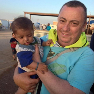 Handout image received from Britain's Foreign and Commonwealth Office on September 15, 2014 shows British aid worker, Alan Henning holding a child in a refugee camp on the Turkish-Syrian border. (AFP Photo / Foreign and Commonwealth Office)