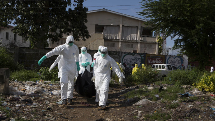 A burial team wearing protective clothing, remove a body of a person suspected of having died of the Ebola virus, in Freetown September 28, 2014.(Reuters / Christopher Black)