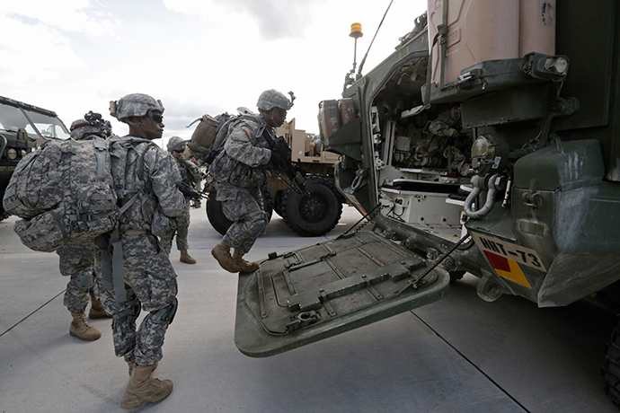 U.S.173 airborne brigade soldiers climb onto armoured personal carrier "Stryker" during the "Steadfast Javelin II" military exercise in the Lielvarde air base, September 6, 2014 (Reuters / Ints Kalnins)
