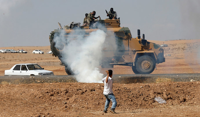 A protester throws stones at an armoured army vehicle during a pro-Kurdish demonstration in solidarity with people of Kobani, near the Mursitpinar border crossing on the Turkish-Syrian border, in the Turkish town of Suruc in southeastern Sanliurfa province October 7, 2014. (Reuters / Umit Bektas) 