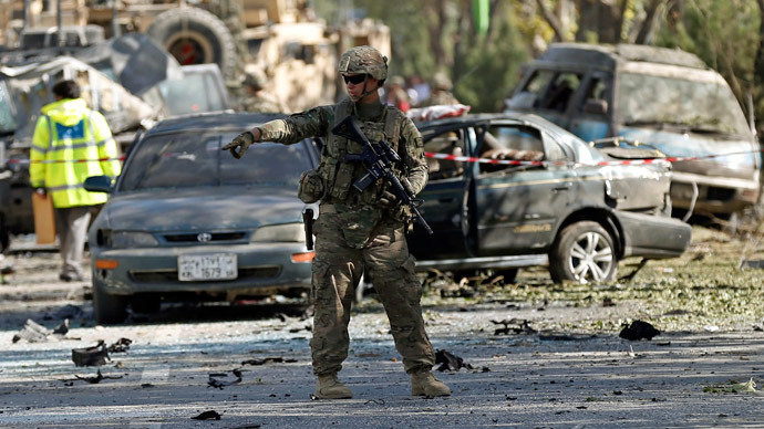 A U.S. soldier stands guard near a damaged vehicle at the site of a suicide attack in Kabul.(Reuters / Mohammad Ismail)