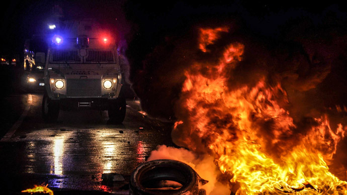 Flames are seen near a Turkish police vehicle on October 7, 2014 in the southeastern city of Diyarbakir during a demonstration of Kurdish to demand more western intervention against Islamic State militants (IS) in Syria and Iraq.(AFP Photo / Ilyas Akengin)