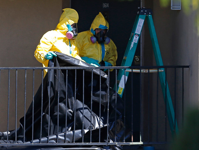 Workers wearing hazardous material suits arrive at the apartment unit where a man diagnosed with the Ebola virus was staying in Dallas, Texas, October 3, 2014. (Reuters / Jim Young)