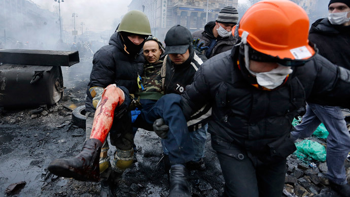 Anti-government protesters carry a man with a bullet wound on his leg during clashes with riot police in the Independence Square in Kiev February 20, 2014. (Reuters / Yannis Behrakis)