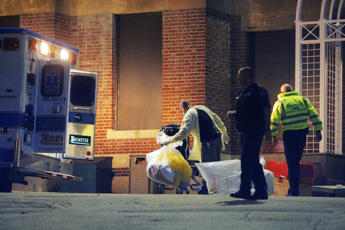A man collects and bags items behind the ambulance used to transport a patient with possible Ebola symptoms to Beth Israel Deaconess Medical Center in Boston, Massachusetts October 12, 2014. (Reuters/Brian Snyder)