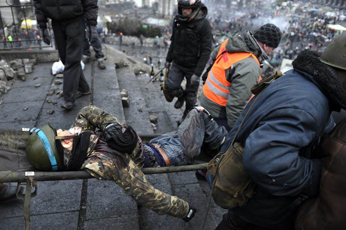 Protesters evacuate a wounded demonstrator from Independence square, dubbed Maidan, in Kiev on February 20, 2014. (AFP Photo/Louisa Gouliamaki)
