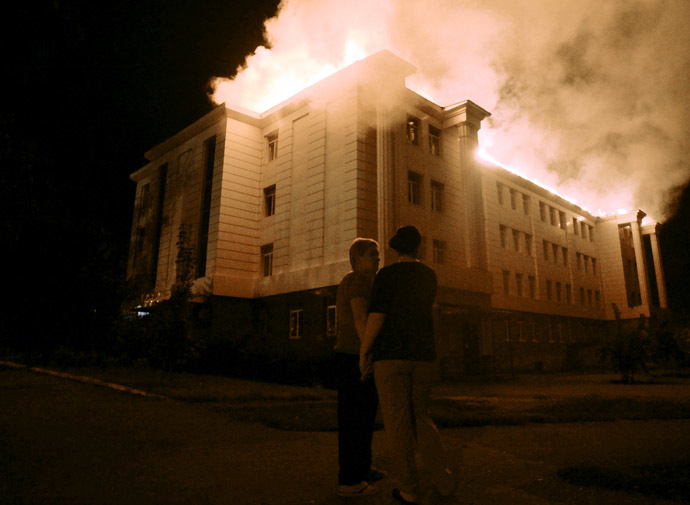 Bystanders watch a fire consuming a school in downtown Donetsk on August 27, 2014. (AFP Photo/Francisco Leong)