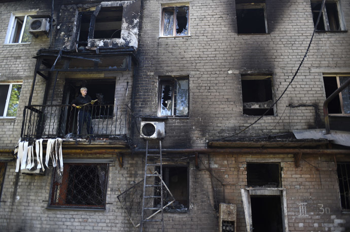 A man cleans up his burnt flat after a building was hit by shelling this morning in the Kievsky district near the international airport on September 17, 2014 in Donetsk, eastern Ukraine. (AFP Photo/Philippe Desmazes)