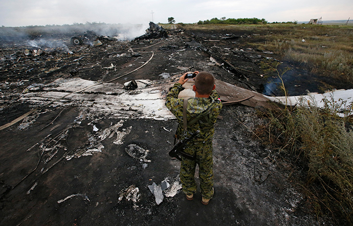 A man takes pictures at the site of a Malaysia Airlines Boeing 777 plane crash, MH17, near the settlement of Grabovo in the Donetsk region, July 17, 2014 (Reuters / Maxim Zmeyev)