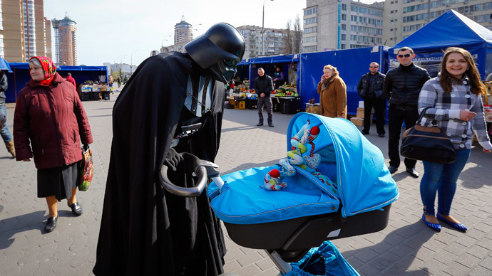 "Darth Vader", the leader of the Internet Party of Ukraine, looks at a child in a pram at a street market near the Ukrainian Central Elections Commission in Kiev April 3, 2014.(Reuters / Shamil Zhumatov)
