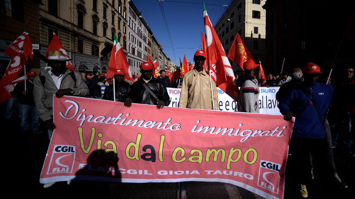 Immigrant farmers hold a banner reading "away from the field" during a demonstration organised by Italian General Confederation of Labour (CGIL) union on October 25, 2014 in central Rome.(AFP Photo / Filippo Monteforte)