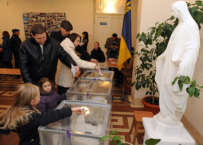 People post ballots in a polling station in Lviv on October 26, 2014. (AFP Photo/Yurko Dyachyshyn)