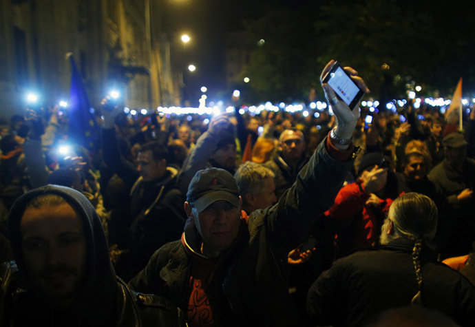 People hold up their mobile phones as they protest against a new tax on Internet data transfers in the centre of Budapest, October 28, 2014. (Reuters/Laszlo Balogh)