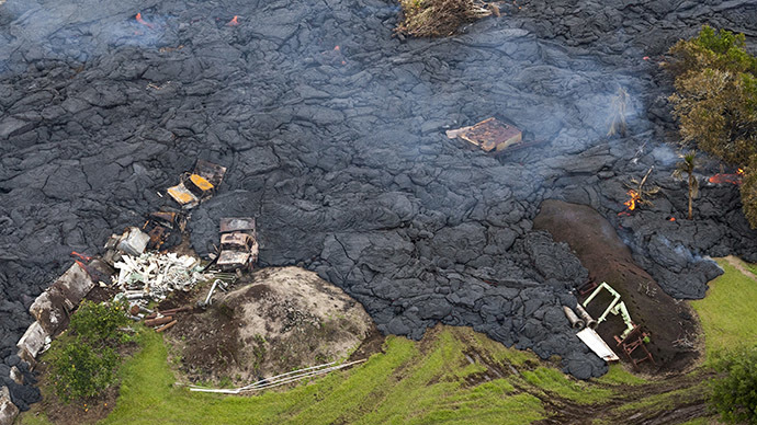 Burning debris can be seen in the lava flow from Mount Kilauea that is inching closer to the village of Pahoa, Hawaii October 29, 2014. (Reuters/Marco Garcia)