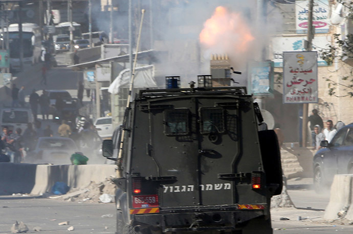 A vehicle of Israeli security forces drives during clashes with Palestinian protesters at the Israeli Qalandia checkpoint between the West Bank city of Ramallah and Jerusalem on November 7, 2014, following a protest against Israel's restrictions at the Al-Aqsa Mosque in Jerusalem. (AFP Photo/Abbas Momani)