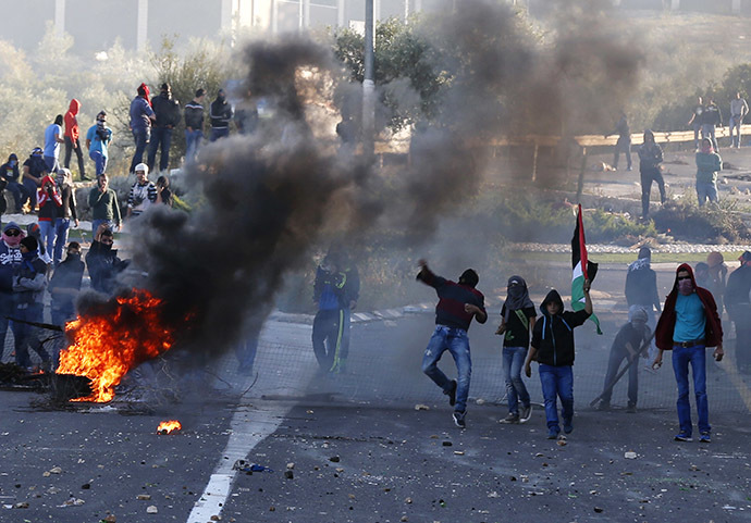 Israeli Arab youths throw stones during clashes with Israeli police at the entrance to the town of Kfar Kanna, in the North of Israel, November 8, 2014. (Reuters/Ammar Awad)