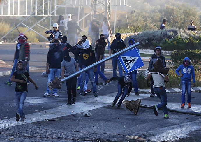 Israeli Arab youths clash with Israeli police at the entrance to the town of Kfar Kanna, North of Israel, November 8, 2014. (Reuters/Ammar Awad)