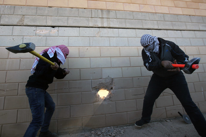 Palestinian youths use sledgehammers to break parts from a concrete segment of the controversial Israeli separation wall in the West Bank village of Bir Nabala -between Jerusalem and Ramallah- on November 8, 2014 as celebrations today mark 25 years since the fall of the Berlin Wall. (AFP Photo)