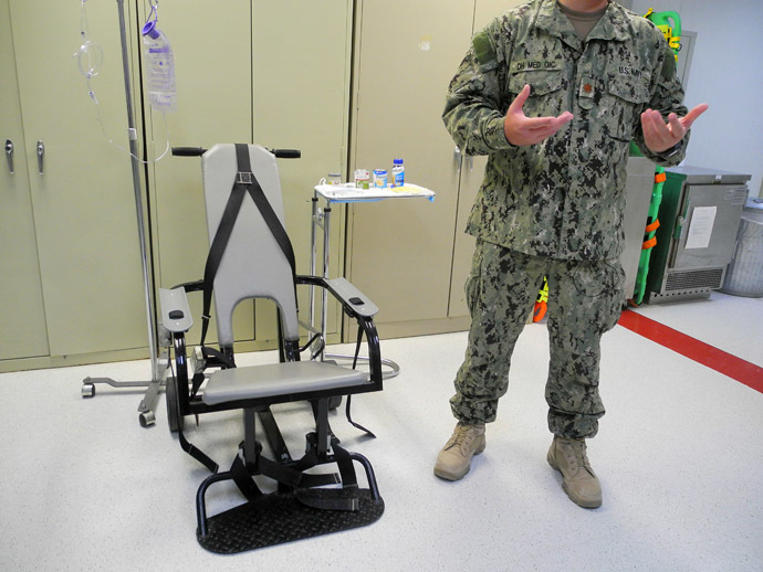 A US naval medic explains the feeding chair at the US Naval Base in Guantanamo Bay, Cuba on August 7, 2013. (AFP Photo/Chantal Valery)