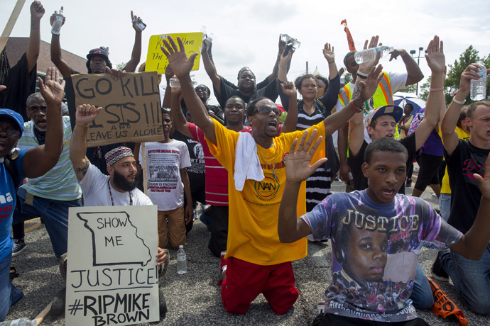 Protesters sit down in the street outside the police department during a protest over the killing of Michael Brown August 30, 2014 in Ferguson, Missouri. (Aaron P. Bernstein / Getty Images / AFP)
