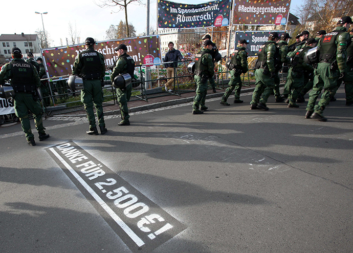 Picture taken on November 15, 2014 in Wunsiedel, southern Germany, shows policemen standing next to banners of the action group "Wunsiedel is Colorful" along the route of a demonstration by far-right extremists. (AFP Photo / Fricke) 