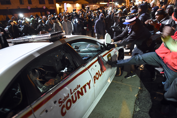 Protesters attack a police car during clashes following the grand jury decision in the death 18-year-old Michael Brown in Ferguson, Missouri, on November 24, 2014 (AFP Photo / Jewel Samad)