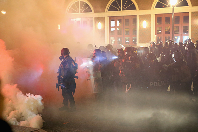 Police guard the Ferguson police department as rioting erupts following the grand jury announcement in the Michael Brown case on November 24, 2014 in Ferguson, Missouri (AFP Photo / Scott Olson)