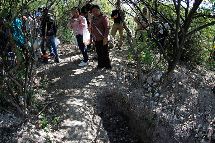 People with missing relatives stand around mass graves discovered in October, in La Joya, on the outskirts of Iguala, Guerrero state, November 21, 2014 (Reuters / Jorge Dan Lopez)