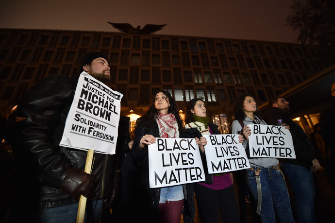 Demonstrators stand and chant with placards during a protest outside the US embassy in London on November 26, 2014 over the US court decision not to charge the policeman who killed unarmed black teenager Michael Brown in the town of Ferguson. (AFP Photo/Leon Neal)