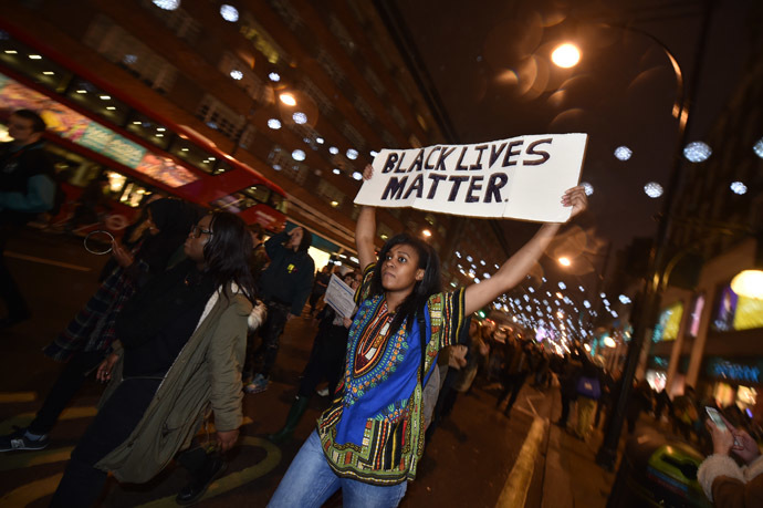Demonstrators hold up placards and march down Oxford Street in central London on November 26, 2014 during a protest over the US court decision not to charge the policeman who killed unarmed black teenager Michael Brown in the town of Ferguson. (AFP Photo/Leon Neal)