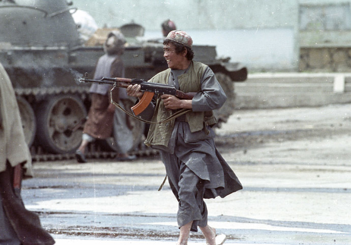 A Dostum mujahideen fighter runs as he fires his AK-47 machine gun against advancing Hezb-i-Islami rebels at the Bala Hishar palace in Kabul on April 26, 1992. (Reuters/Richard Ellis)