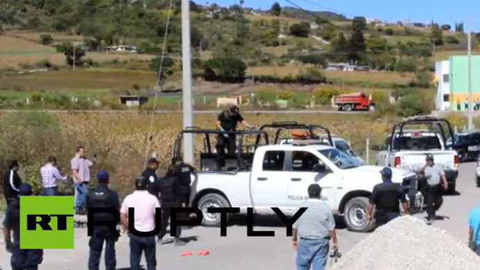 Mexican police inspecting the scene where 11 dead bodies were found on the side of a road in Chilapa on November 27, 2014. (A still from Ruptly video)