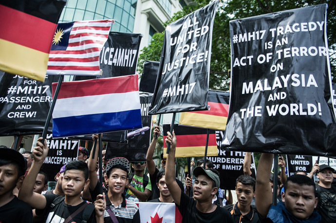 Youths hold placards and Malaysian flags during a Malaysia Airlines flight MH17 solidarity gathering outside the Parliament house in Kuala Lumpur July 23, 2014. (AFP Photo)