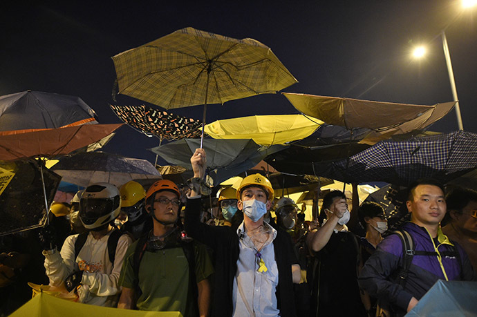 Demonstrators hold umbrellas, a symbol of the pro-democracy protests, amid a clash with police during the protest near the government headquarters in Hong Kong on November 30, 2014. (AFP Photo/Philippe Lopez)