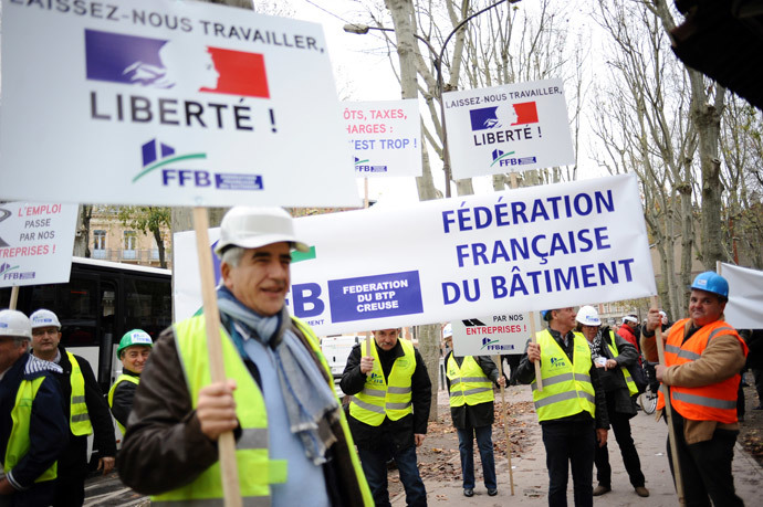 Members of the "Federation Francaise du Batiment" hold signs (L) reading "Let us work, freedom!" as French bosses protest on December 1, 2014 in Toulouse against 30 years of government economic policies that have, according to them, stunted economic growth. (AFP Photo / Remy Gabalda)