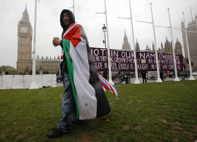 A pro-Palestine supporter wears a Palestinian and Union flag outside the Houses of Parliament in London October 13, 2014. (Reuters/Luke MacGregor)