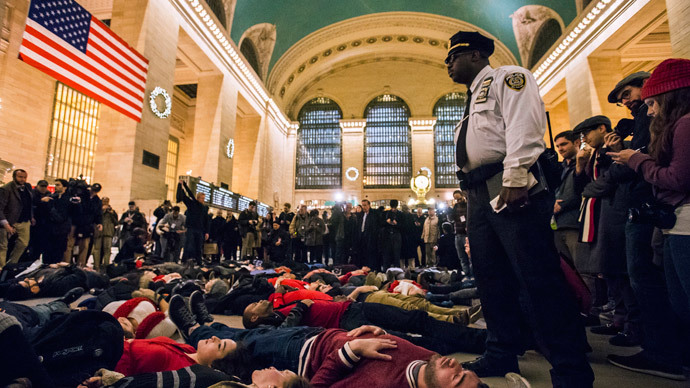 A police officer stands over activists, demanding justice for the death of Eric Garner, as they stage a 'die-in' during rush hour at Grand Central Terminal in the Manhattan borough of New York on December 3, 2014.(Reuters / Adrees Latif)
