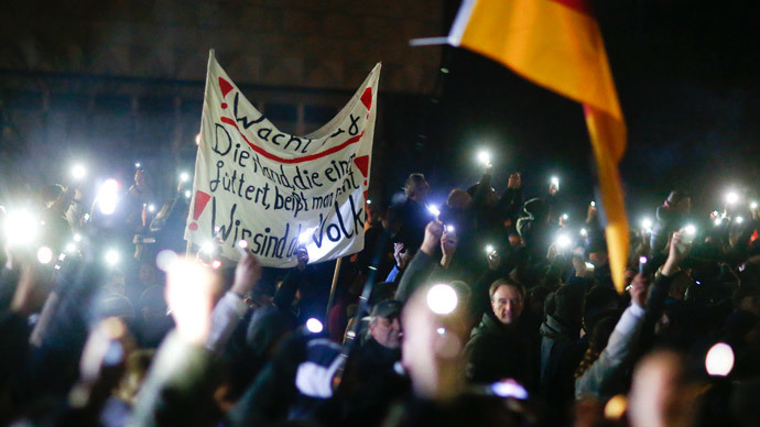 Participants hold up their mobile phones and wave a German national flag during a demonstration called by anti-immigration group PEGIDA, a German abbreviation for "Patriotic Europeans against the Islamization of the West", in Dresden December 8, 2014.(Reuters / Hannibal Hanschke)