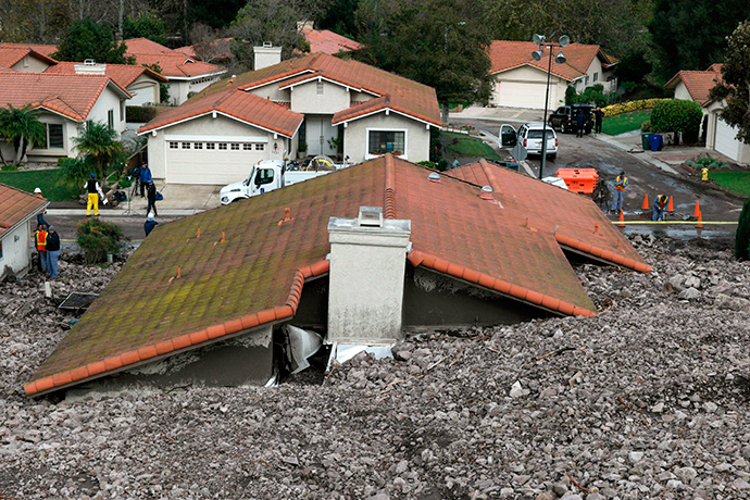 TV news crews set up across from a damaged home after a mud slide overtook at least 18 homes during heavy rains in Camarillo Springs, California December 12, 2014 (Reuters / Jonathan Alcorn)