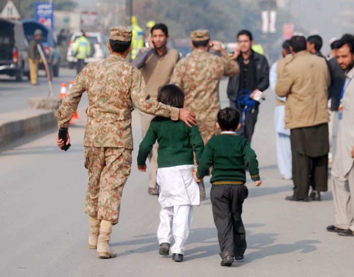 A soldier escorts schoolchildren after they were rescued from the Army Public School that is under attack by Taliban gunmen in Peshawar, December 16, 2014. (Reuters/Khuram Parvez)