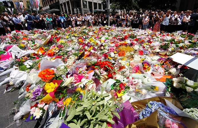 Members of the public look at thousands of floral tributes placed near the cafe in central Sydney December 16, 2014 where hostages were held for over 16-hours (Reuters / David Gray)