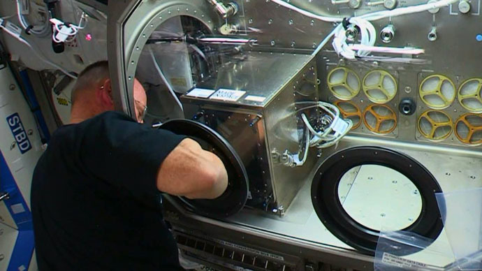 Butch reaches into the Microgravity Science Glovebox to operate the 3D printer (Image Credit: NASA)