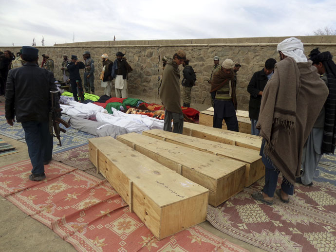 Afghan men gather around the bodies of victims of Sunday's suicide attack at a volleyball match in Yahya Khail district, Paktika province, November 24, 2014. (Reuters)