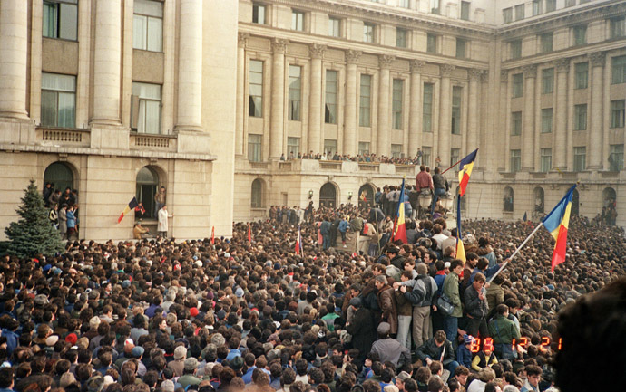 Bucharest citizens wave Romanian flags in an anti-communist demonstration on Republic Square, December 21, 1989 in front of Romanian Communist Party Central Committee HQ (background), starting a national upraising to end Nicolae Ceausescu's 24 years of dictatorial rule. (AFP Photo)