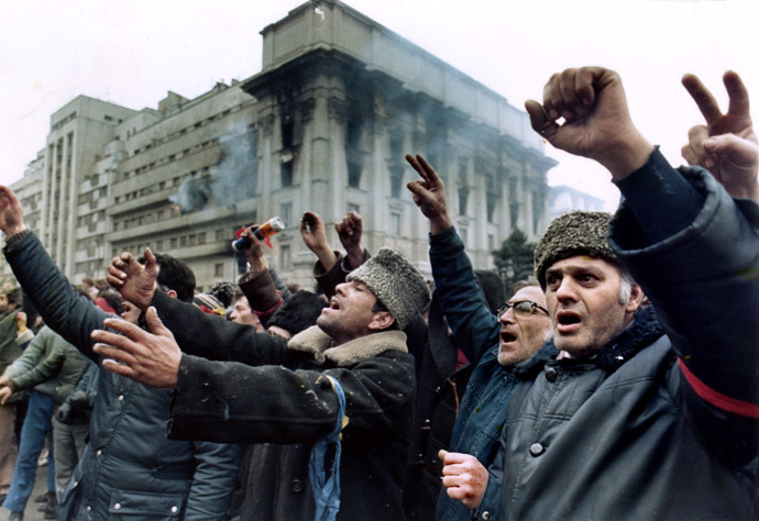Bucharest residents demonstrate in front of a burning building at Republic Square, asking for freedom and democracy December 24, 1989. (Reuters)