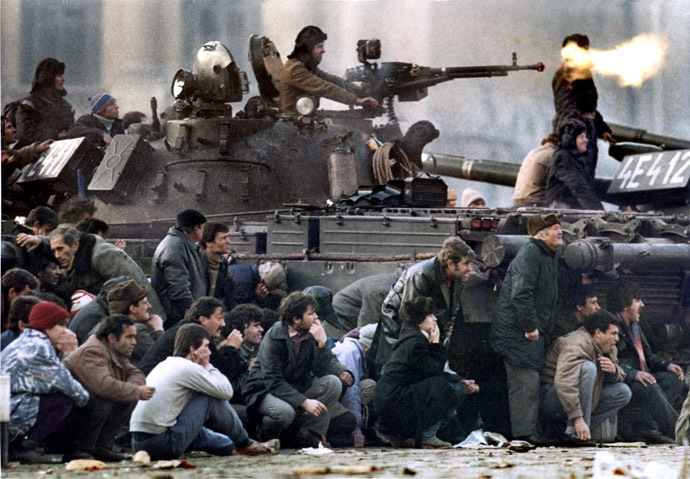 Bucharest residents protect themselves from the crossfire between an army tank and pro-Ceausescu troops during clashes in Republican Square, December 23, 1989. (Reuters)