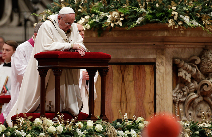 Pope Francis kneels as he leads the Christmas night mass in Saint Peter's Basilica at the Vatican December 24, 2014 (Reuters / Max Rossi)