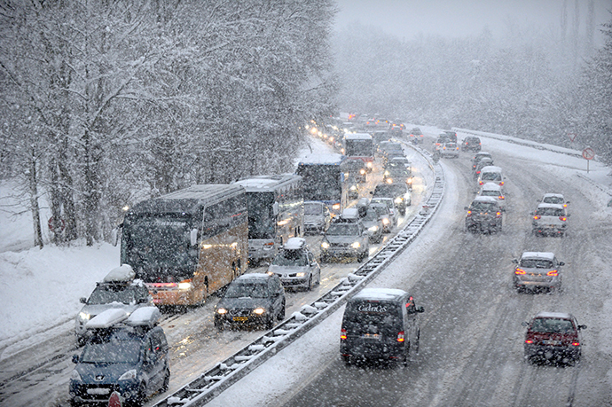 Snow fall as vehicles move bumper-to-bumper along the motorway near Albertville, on December 27, 2014 as they make their way into the Tarentaise valley in the heart of the French Alps, home to many of the famous French ski resorts. (AFP Photo / Jean-Pierre Clatot) 