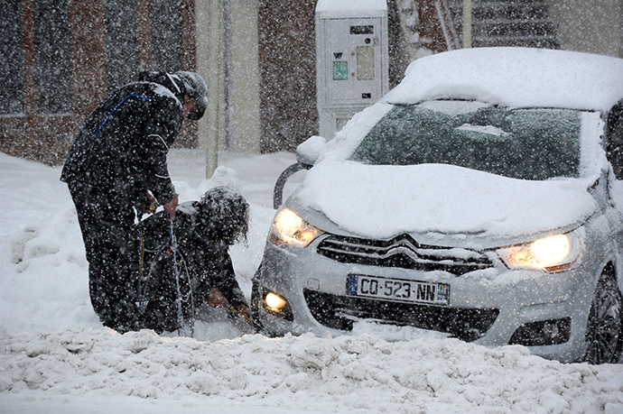 People put snow chains on their tires as snow falls on December 27, 2014 on the road to the Les Saisies ski resort in Savoie, central-eastern France. (AFP Photo / Jean-Pierre Clatot)