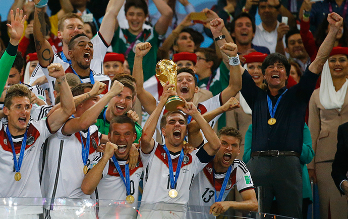 Germany's players celebrate with the trophy next to their coach Joachim Loew (2nd R) after winning their 2014 World Cup final against Argentina at the Maracana stadium in Rio de Janeiro July 13, 2014. (Reuters / Kai Pfaffenbach)